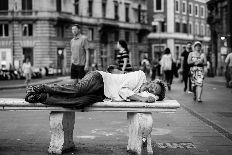 Un uomo povero che dorme su una panchina